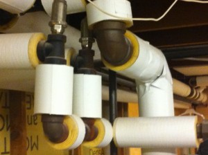 Hot water pipes wrapped with foam insulation to reduce heat loss